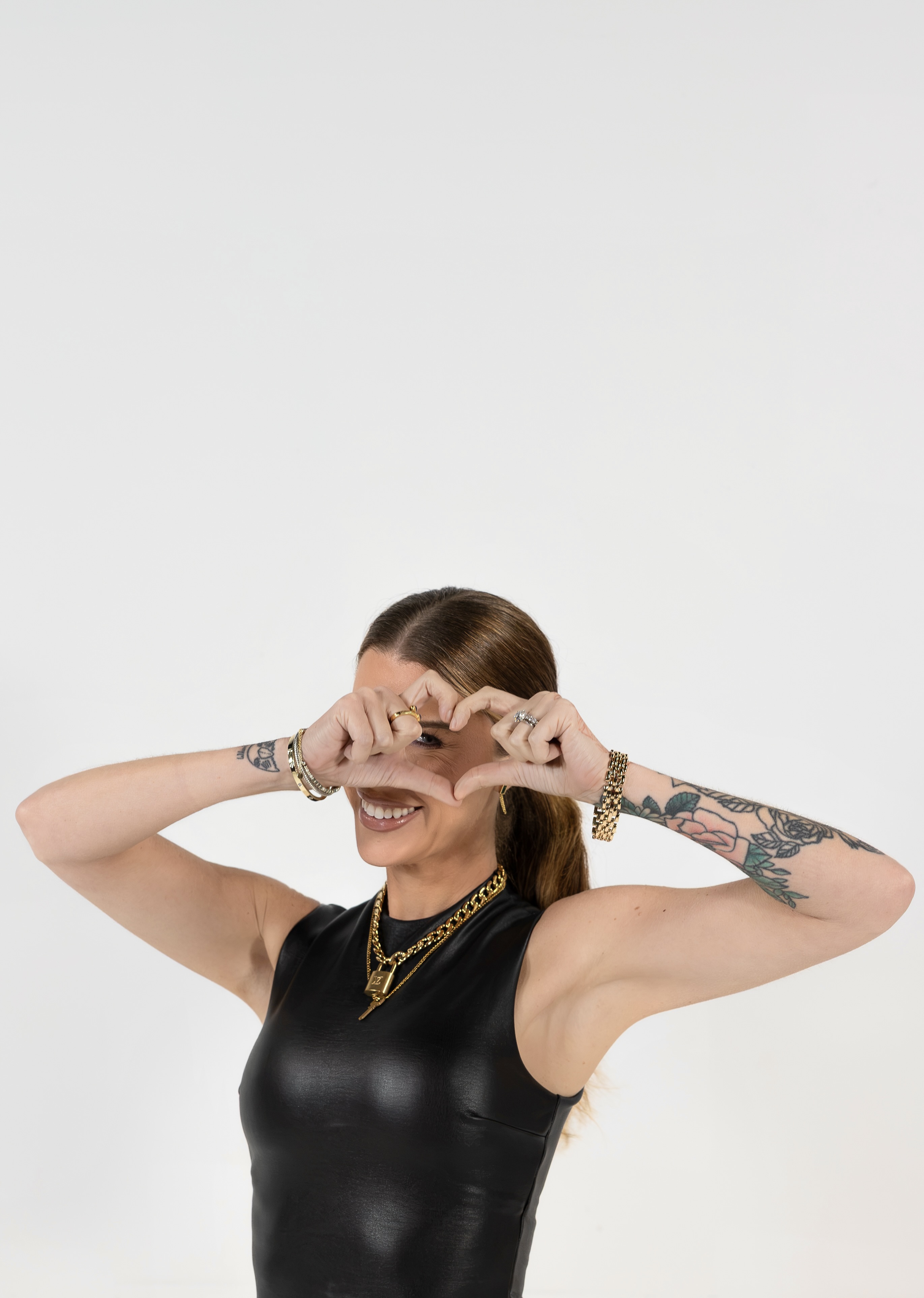 Ashley Tomblin smiling, making a heart with her hands.