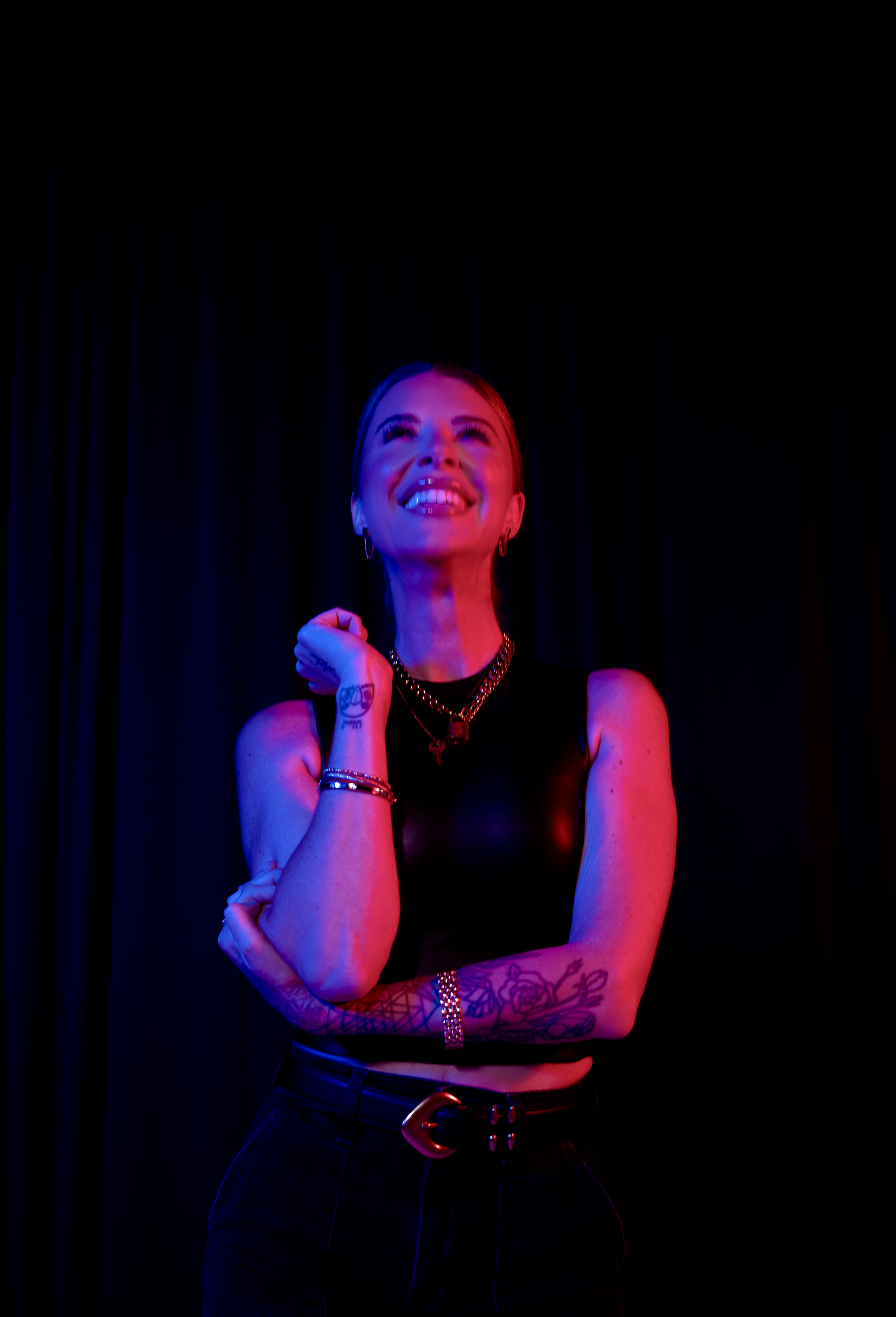Ashley Tomblin laughing under stage lighting.